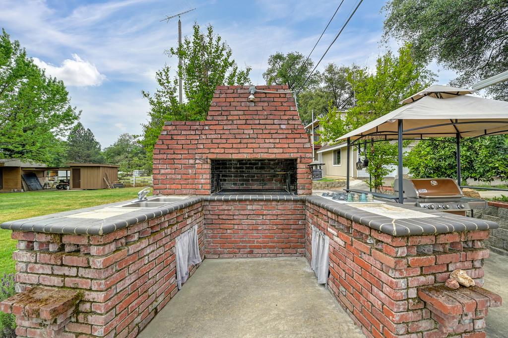 5682 Virginiatown Road Newcastle, CA 95658 - Photo 21 of 56 Outdoor brick kitchen area for grilling with four burner cooktop and sink.
