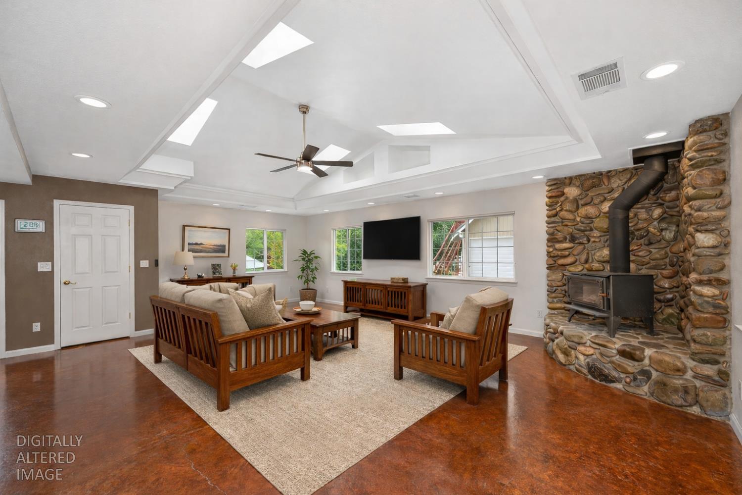 5682 Virginiatown Road Newcastle, CA 95658 - Photo 7 of 56 Spacious great room anchored by a striking ornate river rock hearth and a dramatic vaulted cathedral ceiling with skylights, recessed lighting, and custom architectural detailing creating an open, light-filled space.