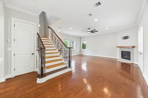 a view of a livingroom with wooden floor and staircase