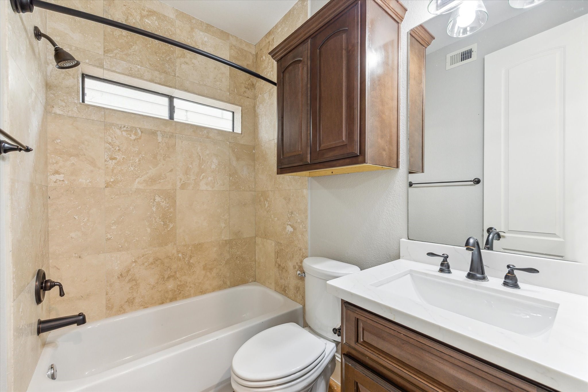 1512 Thompson Street, Unit 3 Houston, TX 77007 - Photo 26 of 32 Guest bathroom for the two secondary bedrooms on the first floor. New vanity and lights added in 2025. Shower/tub combo for convenience.