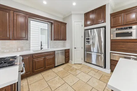 a kitchen with granite countertop a refrigerator and a stove top oven