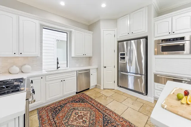 a kitchen with stainless steel appliances a refrigerator sink and cabinets