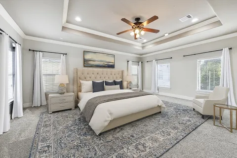 a spacious bedroom with a large bed and a chandelier
