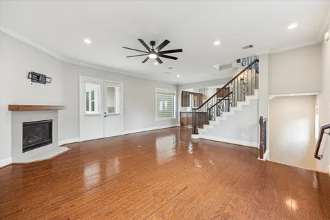 a view of an empty room with wooden floor fireplace and a window