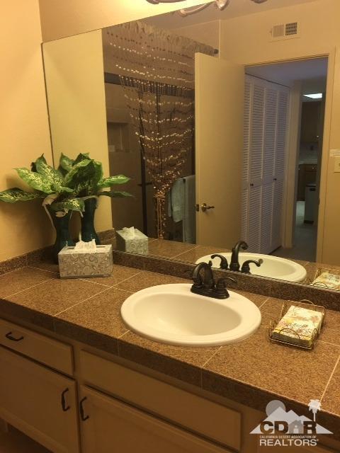 63 Torremolinos Drive Rancho Mirage, CA 92270 - Photo 13 of 32 a bathroom with a granite countertop sink and a mirror