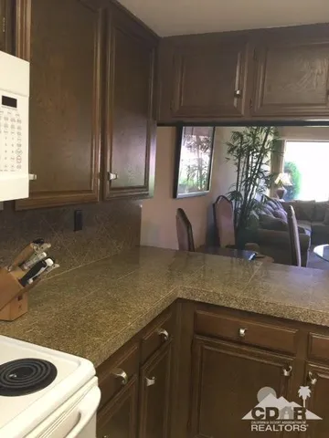 a kitchen with granite countertop a sink a stove and cabinets