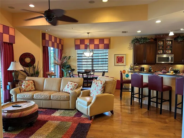 a living room with furniture a ceiling fan and a rug