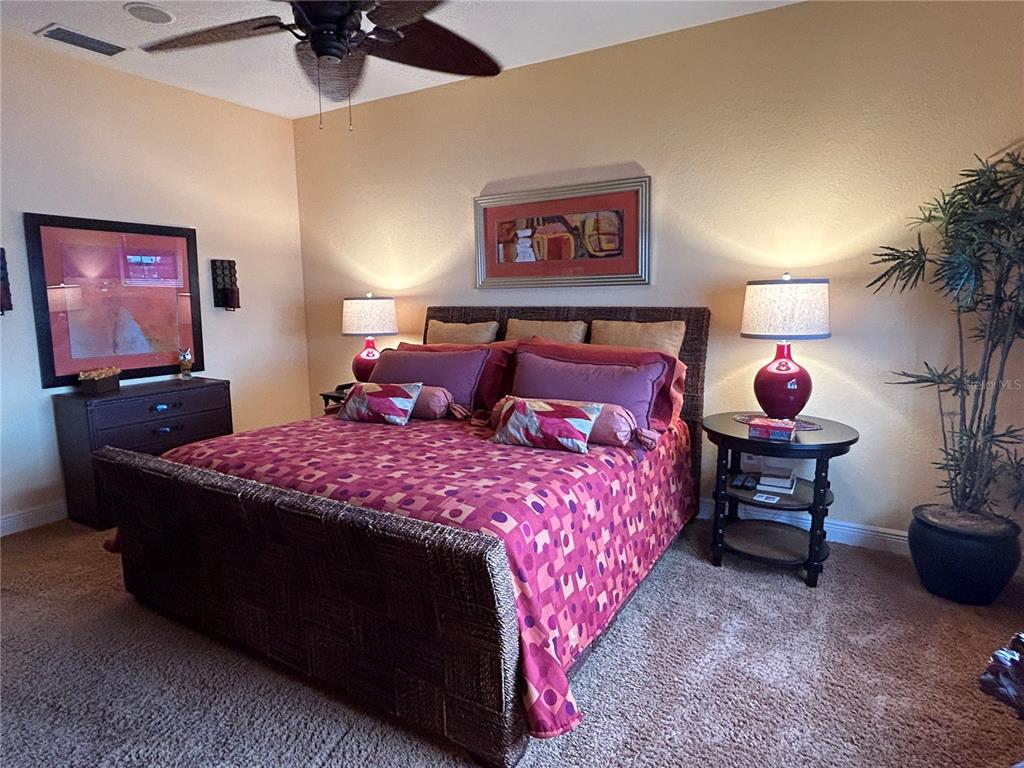 1139 Riverscape Street, Unit 1139 Bradenton, FL 34208 - Photo 21 of 45 a bedroom with a bed and a chandelier
