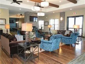 a living room with furniture a chandelier and a dining table