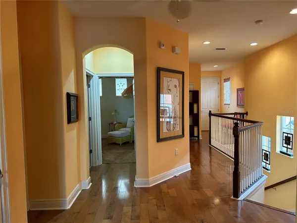 a view of a hallway with wooden floor and furniture