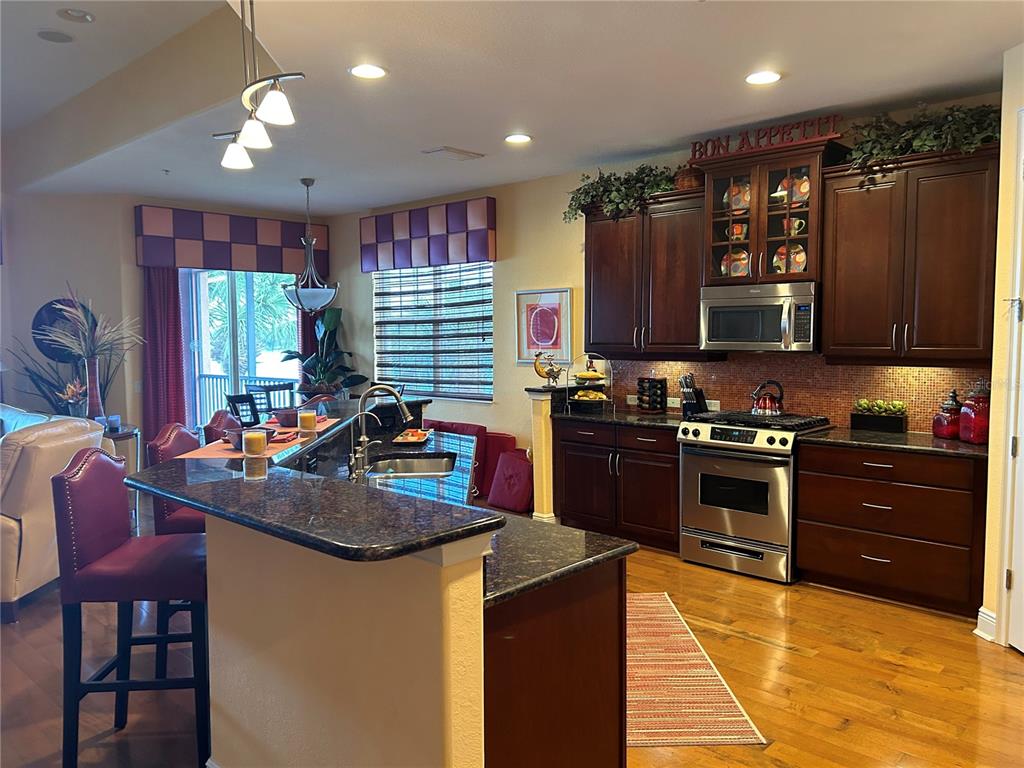 1139 Riverscape Street, Unit 1139 Bradenton, FL 34208 - Photo 8 of 45 a kitchen with a stove a sink a refrigerator and chairs