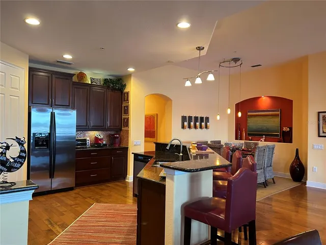 a kitchen with sink a refrigerator and chairs