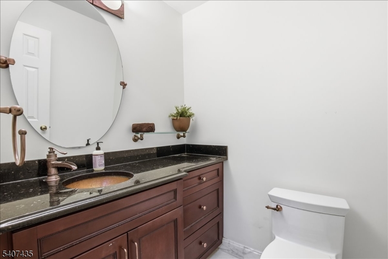 139 Riveredge Drive, Unit 139 Chatham, NJ 07928 - Photo 13 of 32 a bathroom with a granite countertop sink and a toilet