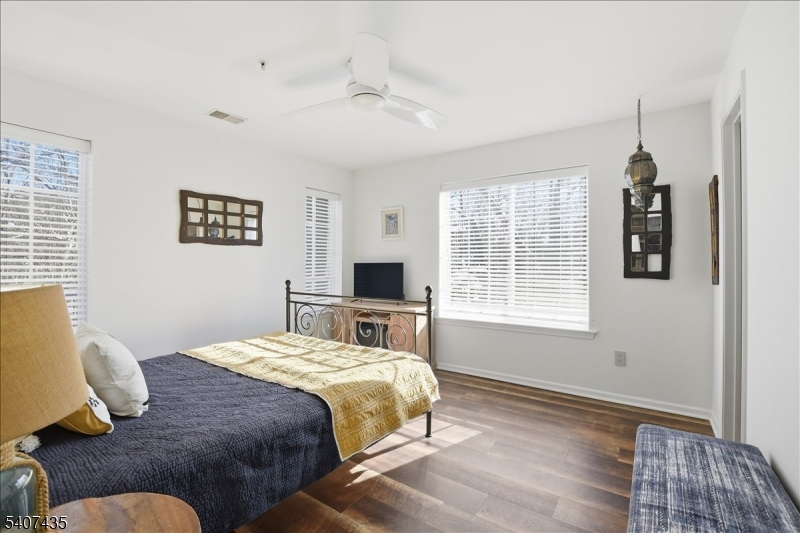 139 Riveredge Drive, Unit 139 Chatham, NJ 07928 - Photo 18 of 32 a bedroom with a bed and wooden floor