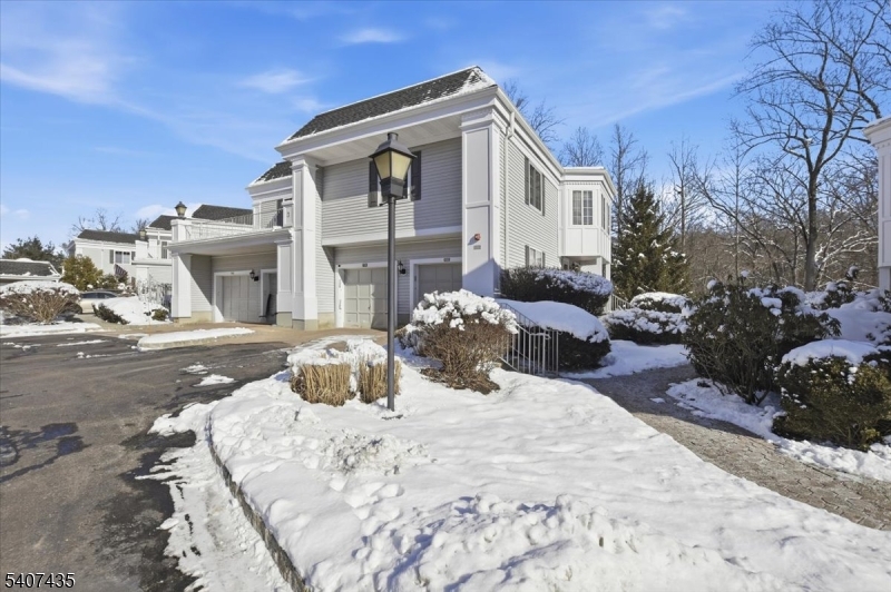 139 Riveredge Drive, Unit 139 Chatham, NJ 07928 - Photo 27 of 32 a view of a white house with a yard covered in snow