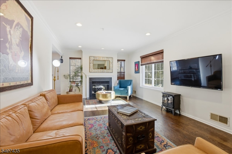139 Riveredge Drive, Unit 139 Chatham, NJ 07928 - Photo 3 of 32 a living room with furniture a flat screen tv and a fireplace