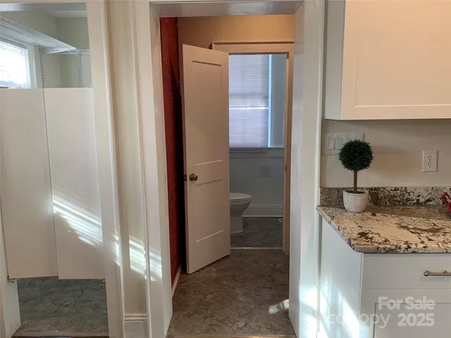 a bathroom with a granite countertop sink a toilet and shower