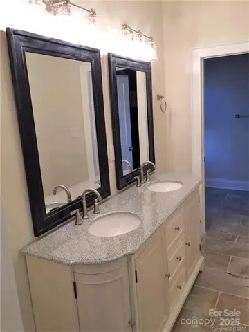 a bathroom with a double vanity sink and a mirror