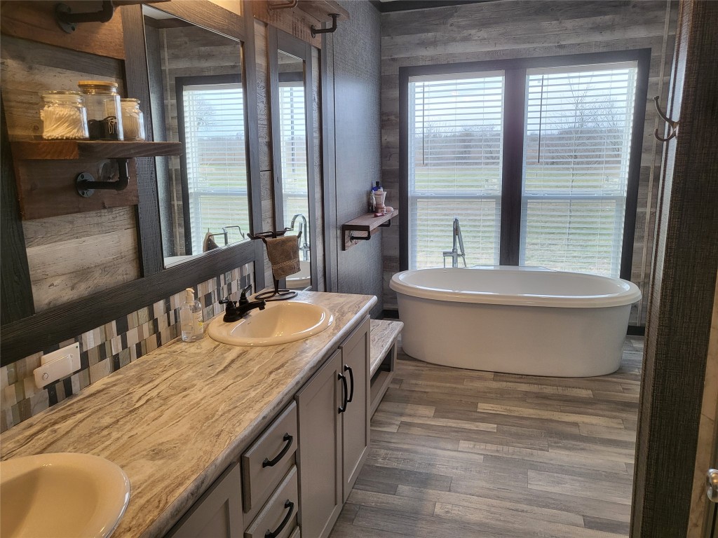 192 Lazy River Lane Elgin, TX 78621 - Photo 8 of 12 Full bathroom with a freestanding tub, double vanity, and dark wood-style floors