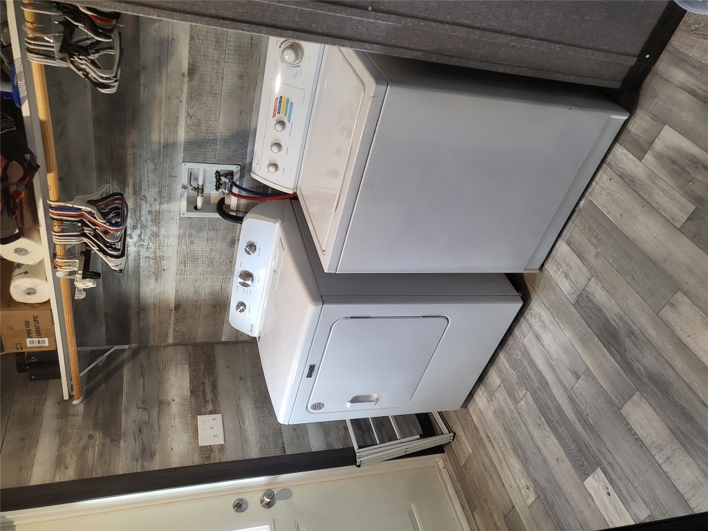 192 Lazy River Lane Elgin, TX 78621 - Photo 9 of 12 Laundry area featuring washing machine and clothes dryer, light wood finished floors, and wooden walls