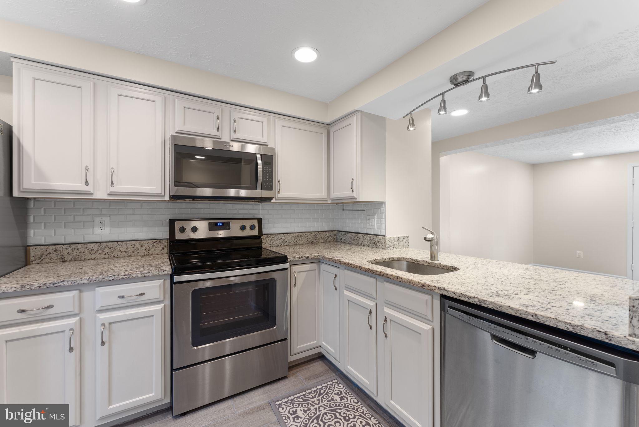 1644 Fieldthorn Drive Reston, VA 20194 - Photo 7 of 43 a kitchen with granite countertop a sink stainless steel appliances and white cabinets