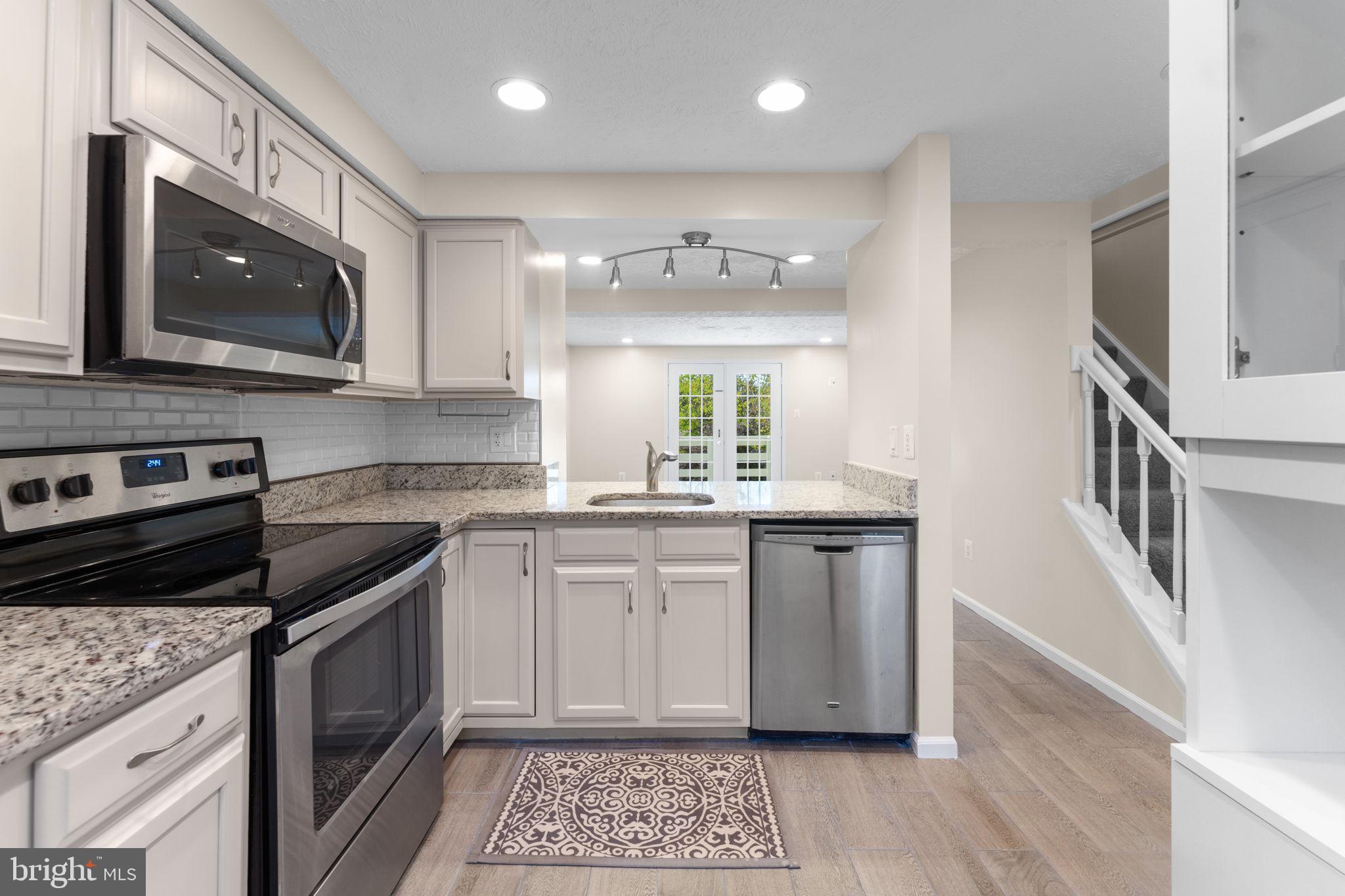 1644 Fieldthorn Drive Reston, VA 20194 - Photo 10 of 43 a kitchen with stainless steel appliances granite countertop a stove a sink and a microwave