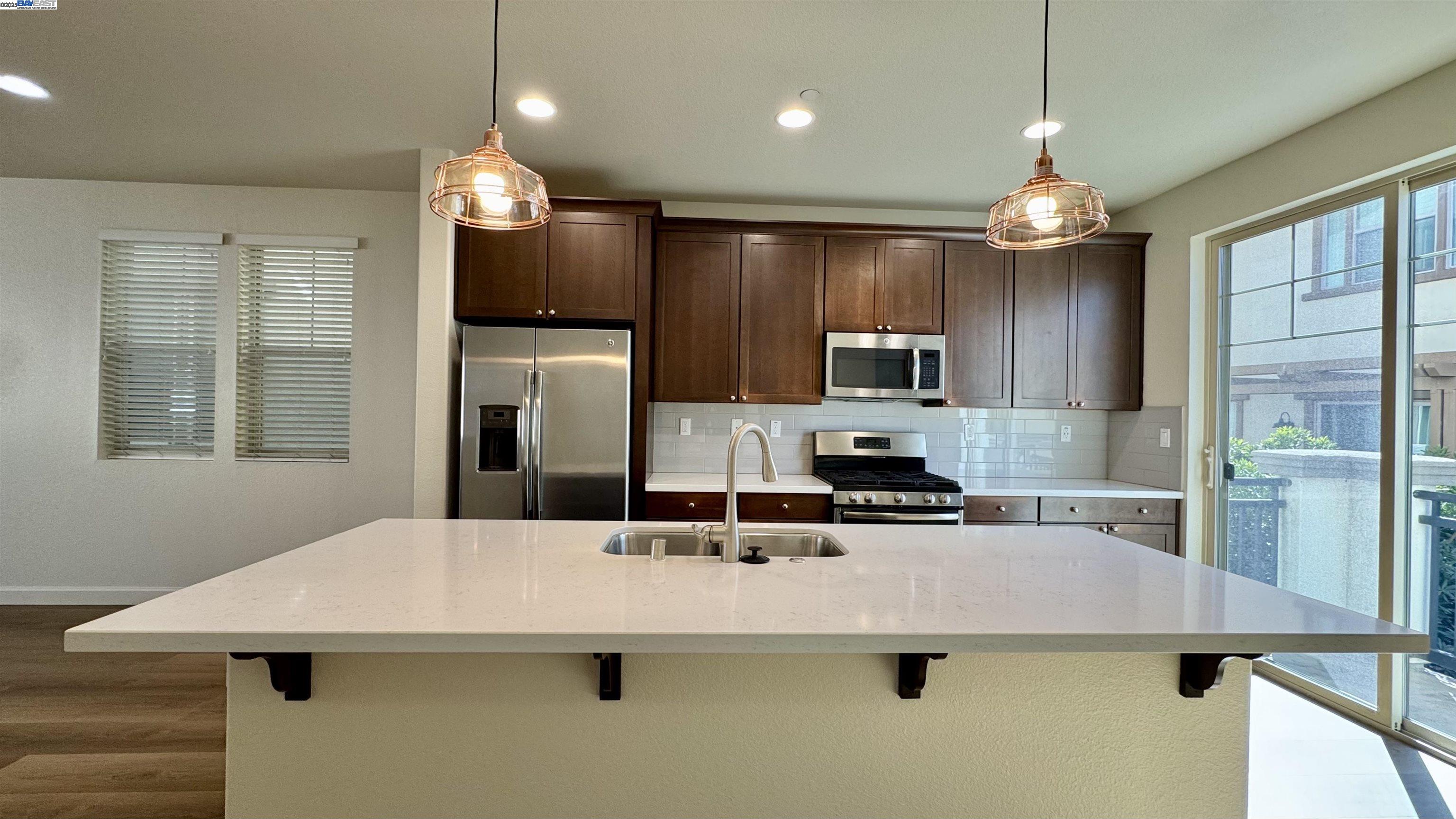 2906 Worthing Common Livermore, CA 94550 - Photo 16 of 31 a kitchen with kitchen island a sink stainless steel appliances and chandelier