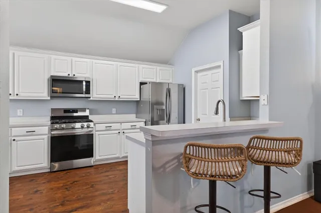 a kitchen with stainless steel appliances granite countertop a stove a sink dishwasher and a refrigerator