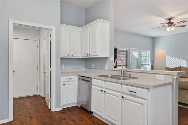 a kitchen with a sink cabinets and wooden floor
