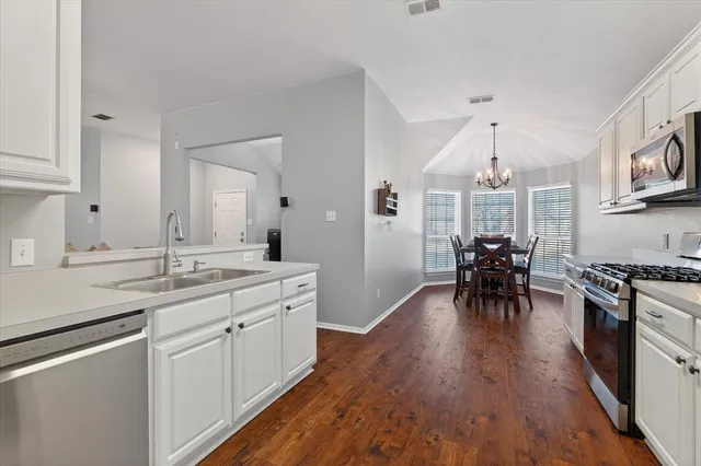 a kitchen with sink cabinets and wooden floor