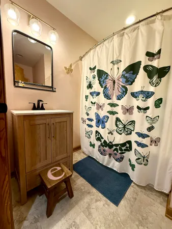 a bathroom with a sink and mirror with shower curtain
