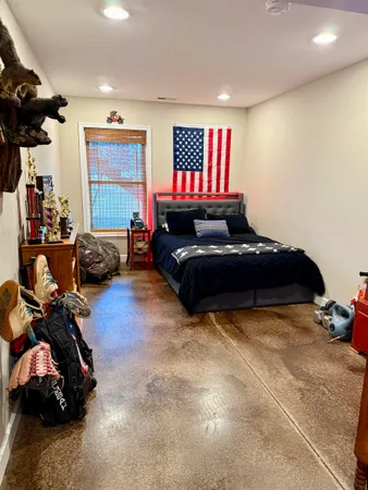 a living room with a bed furniture and a flat screen tv