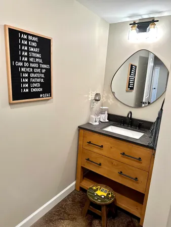a bathroom with a toilet a sink and mirror
