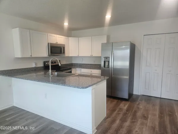 a kitchen with stainless steel appliances granite countertop a sink stove and microwave