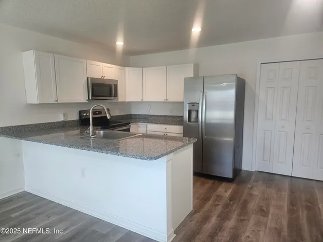 a kitchen with stainless steel appliances granite countertop a sink stove and microwave