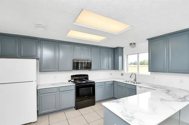 a kitchen with a sink a stove a refrigerator and a microwave