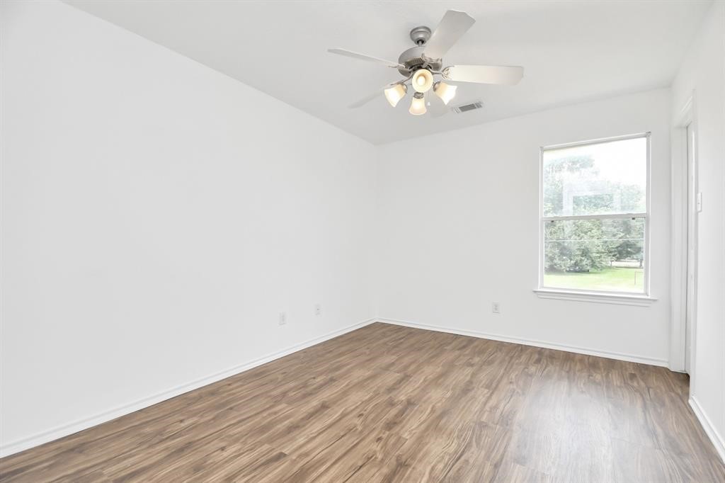 21818 Dimmett Way Spring, TX 77388 - Photo 18 of 35 an empty room with wooden floor and windows