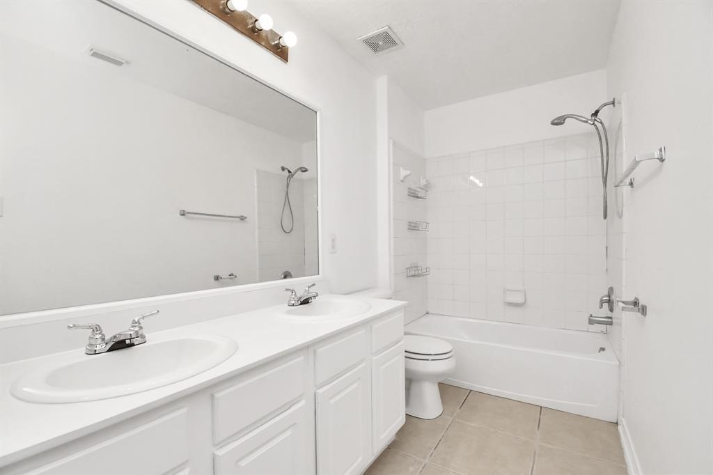21818 Dimmett Way Spring, TX 77388 - Photo 27 of 35 a bathroom with a double vanity sink toilet mirror and bathtub