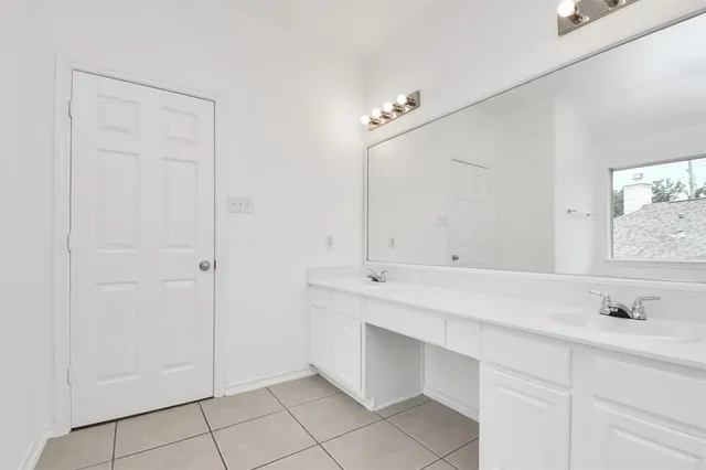 a spacious bathroom with a sink and a mirror