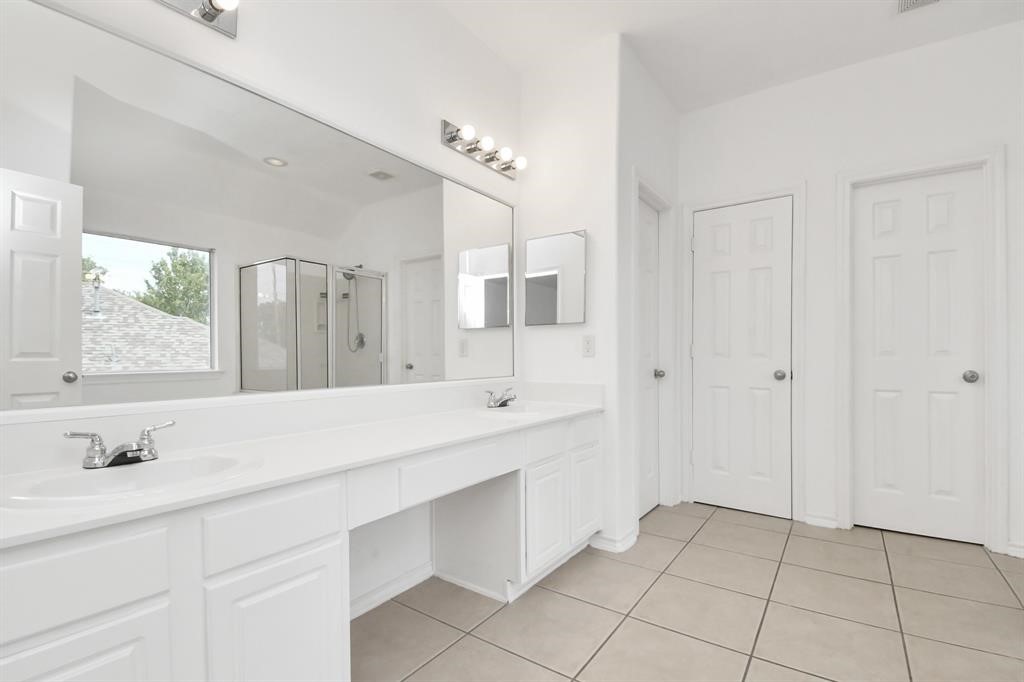 21818 Dimmett Way Spring, TX 77388 - Photo 31 of 35 a spacious bathroom with a double vanity sink a mirror and a shower
