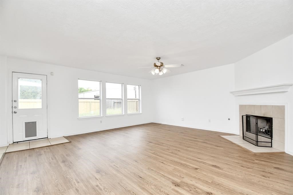 21818 Dimmett Way Spring, TX 77388 - Photo 4 of 35 an empty room with wooden floor fireplace and windows