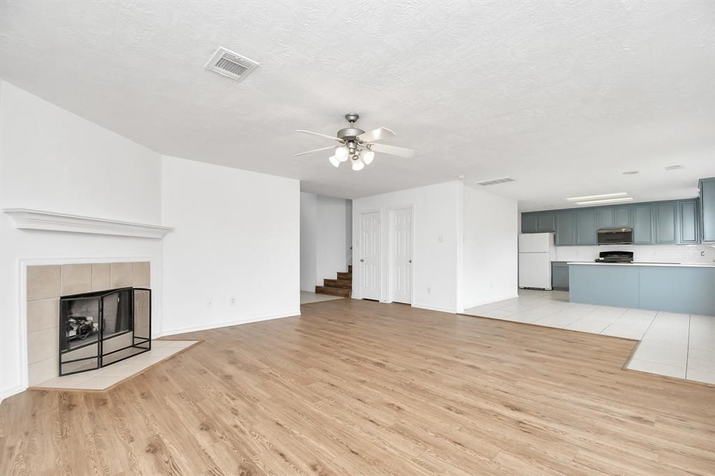 21818 Dimmett Way Spring, TX 77388 - Photo 6 of 35 a view of an empty room with a fireplace and a kitchen view