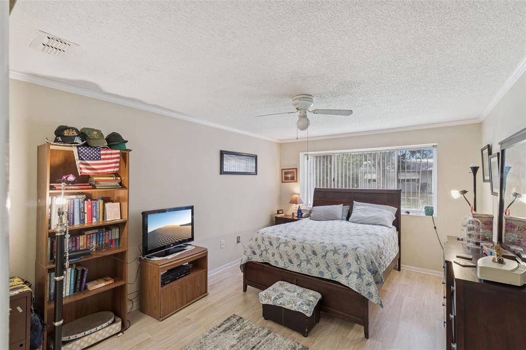 10943 Southwest 86th Court Ocala, FL 34481 - Photo 21 of 35 a bedroom with furniture and a flat screen tv