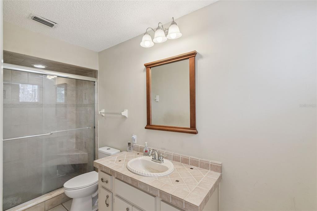 10943 Southwest 86th Court Ocala, FL 34481 - Photo 24 of 35 a bathroom with a sink a toilet and shower