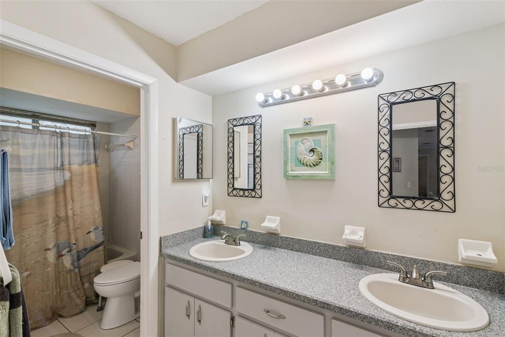 10943 Southwest 86th Court Ocala, FL 34481 - Photo 26 of 35 a bathroom with a toilet a sink a mirror and shower