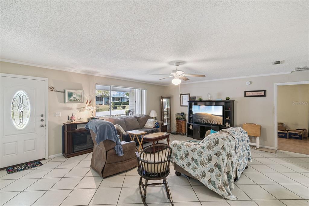 10943 Southwest 86th Court Ocala, FL 34481 - Photo 7 of 35 a living room with furniture a fireplace and a flat screen tv