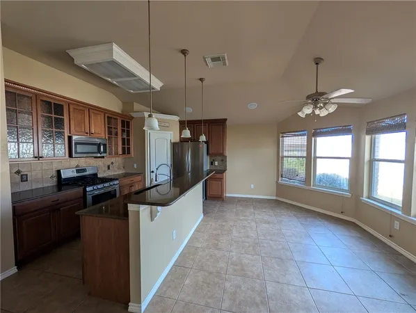 a kitchen with stainless steel appliances granite countertop a stove and cabinets