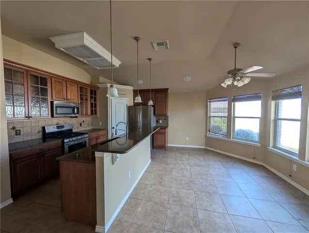 a kitchen with stainless steel appliances granite countertop a stove and cabinets