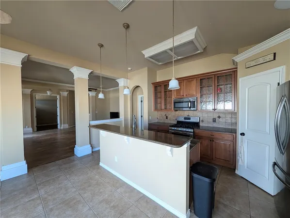 a kitchen with stainless steel appliances granite countertop a refrigerator a stove and a sink