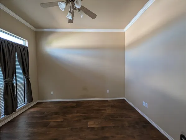 a view of a room with wooden floor and ceiling fan